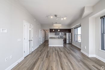 A spacious kitchen with a dining area and a living room with a bar.